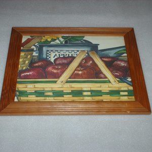 Colorful print of apples framed behind glass